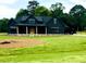 Beautiful two-story home boasts a black exterior, spacious yard and wooded backdrop at 1111 Lake Varner Dr, Covington, GA 30014