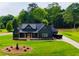 Beautiful two-story home boasts a black exterior, spacious yard and wooded backdrop at 1111 Lake Varner Dr, Covington, GA 30014