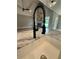 Close-up on kitchen sink with black faucet and granite countertops, complemented by stone fireplace feature at 1111 Lake Varner Dr, Covington, GA 30014