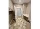 Laundry room with gray tile floors, desk, white cabinets, and gray walls at 1111 Lake Varner Dr, Covington, GA 30014