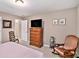 Cozy bedroom featuring carpet floors, neutral paint, and a traditional style dresser with a TV at 127 Courts Of Hampton, Hampton, GA 30228