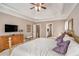 Well-lit bedroom featuring tray ceilings, carpet floors, a brass bed, and a neutral paint at 127 Courts Of Hampton, Hampton, GA 30228