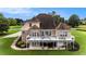 Large two-story home with a deck, covered patio, mature landscaping, and a spacious backyard at 127 Courts Of Hampton, Hampton, GA 30228