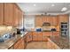 Well-equipped kitchen with granite countertops, wooden cabinets, and stainless steel appliances at 127 Courts Of Hampton, Hampton, GA 30228