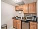 Small kitchenette with wood cabinets, granite countertop, microwave, and mini fridge at 127 Courts Of Hampton, Hampton, GA 30228