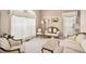 Bright formal living room with elegant furnishings, plush carpet, and large windows with sheer curtains at 127 Courts Of Hampton, Hampton, GA 30228