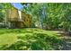 Well-maintained backyard features mature trees, a deck, a walkout basement, and lush lawn at 2120 Habersham Trce, Cumming, GA 30041
