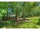 Secluded backyard with mature trees and lush lawn provides a private outdoor retreat at 2120 Habersham Trce, Cumming, GA 30041