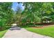 Long driveway leads to a home surrounded by mature trees and lush landscaping at 2120 Habersham Trce, Cumming, GA 30041