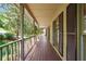 Covered front porch with wood flooring and view of the landscaped yard at 2120 Habersham Trce, Cumming, GA 30041