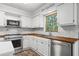 White kitchen with wood countertops, stainless steel appliances, and subway tile backsplash at 2120 Habersham Trce, Cumming, GA 30041