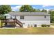 Back exterior of a house with a wood deck and stairs, overlooking a well-maintained lawn at 2675 Springside Ct, Douglasville, GA 30135