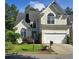 Traditional two-story home with arched windows, a well-manicured lawn, and a two car garage at 3773 Summer Rose Dr, Atlanta, GA 30341