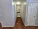 Hallway featuring three white doors, hardwood floors, and a view into the laundry room at 3773 Summer Rose Dr, Atlanta, GA 30341