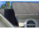 Close-up of architectural shingle roof with white trim and arched windows on a sunny day at 3773 Summer Rose Dr, Atlanta, GA 30341