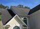 View of architectural shingle roof with white trim and arched windows on a sunny day at 3773 Summer Rose Dr, Atlanta, GA 30341