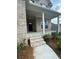 Inviting covered front porch with brick steps and decorative landscaping at 4297 Azalea Ridge Way, Hoschton, GA 30548