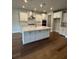 Modern kitchen with white cabinets, a large center island, and stainless steel appliances at 4297 Azalea Ridge Way, Hoschton, GA 30548