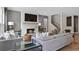 Comfortable living room with a white brick fireplace, a large TV, modern couches, and hardwood flooring at 4297 Azalea Ridge Way, Hoschton, GA 30548