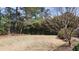 Backyard area with a large grassy area bordered by trees and some bushes at 2886 Thornbriar Rd, Atlanta, GA 30340