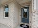 Close up of the front door showing the exterior brick and Pulte Homes welcome mat at 400 Beacon Way, Villa Rica, GA 30180