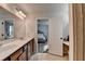 Bright bathroom with double sinks, contemporary lighting, and access to the Primary bedroom at 5215 Wheeler Run Dr, Auburn, GA 30011