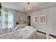 Charming bedroom with sheer curtains, decorative prints, and a classic chandelier overhead at 5215 Wheeler Run Dr, Auburn, GA 30011