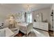 Bright bedroom with floral accents and a chandelier, featuring a large window with natural light at 5215 Wheeler Run Dr, Auburn, GA 30011