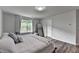 Cozy bedroom showing a comfortable bed with lots of pillows, natural light, and neutral walls at 5215 Wheeler Run Dr, Auburn, GA 30011