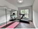 Exercise room with mirrored wall and treadmill, illuminated by natural light through a window at 5215 Wheeler Run Dr, Auburn, GA 30011