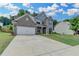 Charming two-story home with gray brick, wide driveway, and lush green lawn at 5215 Wheeler Run Dr, Auburn, GA 30011