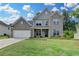 Beautiful two-story home with gray brick, attached garage, and well-manicured lawn at 5215 Wheeler Run Dr, Auburn, GA 30011