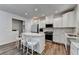 Modern kitchen with white cabinets, stainless steel appliances, wood flooring and quartz countertop at 5215 Wheeler Run Dr, Auburn, GA 30011