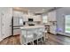 Modern kitchen with white cabinets, stainless appliances, a large island, and wood flooring at 5215 Wheeler Run Dr, Auburn, GA 30011