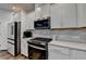 Close up of a modern kitchen featuring stainless steel appliances and quartz countertops at 5215 Wheeler Run Dr, Auburn, GA 30011