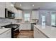 Bright modern kitchen featuring stainless steel appliances, quartz countertops and white cabinets at 5215 Wheeler Run Dr, Auburn, GA 30011