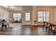Bright living room featuring hardwood floors, piano, and large windows at 5215 Wheeler Run Dr, Auburn, GA 30011
