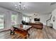 Open concept living area with wood floors, lots of light, a sofa, and a modern chandelier at 5215 Wheeler Run Dr, Auburn, GA 30011