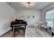 This living room features a baby grand piano and abundant natural light at 5215 Wheeler Run Dr, Auburn, GA 30011