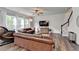 This spacious living room is furnished with leather sofas and a ceiling fan at 5215 Wheeler Run Dr, Auburn, GA 30011