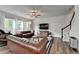A spacious living room is furnished with leather sofas, a ceiling fan, and large windows at 5215 Wheeler Run Dr, Auburn, GA 30011