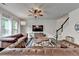 This spacious living room is furnished with leather sofas, a ceiling fan, and a staircase at 5215 Wheeler Run Dr, Auburn, GA 30011