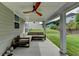 Covered patio with a ceiling fan and stylish sectional sofa, overlooking a lush backyard at 5215 Wheeler Run Dr, Auburn, GA 30011