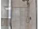 Close-up of a luxurious tiled shower with a rainfall showerhead and sleek glass enclosure at 5215 Wheeler Run Dr, Auburn, GA 30011