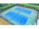Aerial view of well-maintained blue tennis courts with professional lighting for evening play at 5215 Wheeler Run Dr, Auburn, GA 30011