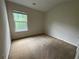 This carpeted bedroom features a window providing natural light at 6941 Rogers Pt, Lithonia, GA 30058