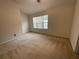 The carpeted bedroom has a window bringing in natural light at 6941 Rogers Pt, Lithonia, GA 30058