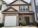Charming two-story townhome with a stone front and a one car garage and a covered entry at 6941 Rogers Pt, Lithonia, GA 30058