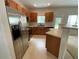 Eat-in kitchen features stainless appliances, wood cabinets, and a bar area at 6941 Rogers Pt, Lithonia, GA 30058