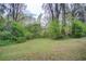Lush backyard features plenty of greenery, grass, and mature trees providing shade and privacy at 2293 Ewing Sw St, Atlanta, GA 30331